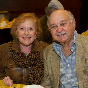 Older couple sitting down together smiling. Read about What to Give Older couple sitting down together smiling. Read about What to Give